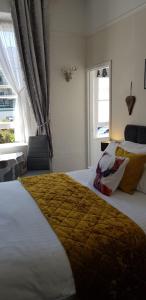 a bedroom with a large bed and a window at Newburgh Guesthouse in Torquay