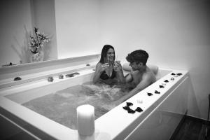un homme et une femme assis dans une baignoire dans l'établissement B&B SAN LORENZO, à Cariati