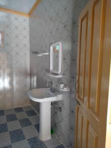 y baño con lavabo blanco y espejo. en Kalash Continental Hotel & Resort, en Chitral