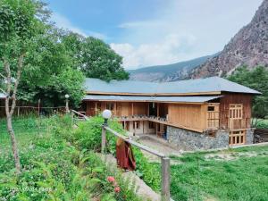 una casa de madera en medio de un campo en Kalash Continental Hotel & Resort, en Chitral