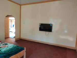 Kalash Continental Hotel & Resort في شيترال: غرفة مع تلفزيون بشاشة مسطحة على الحائط