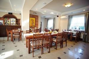 jadalnia z drewnianymi stołami i krzesłami w restauracji w obiekcie Zajazd na Towarowej w mieście Dęblin