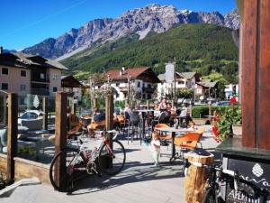 a little girl standing next to a bike on a patio at Hotel Nevada in Bormio