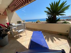 a patio with a table and a bench on a balcony at Mansfield vue carte Postale Terrasse Piscine calme port à 200m à pied in Menton