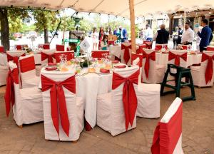 un grupo de mesas con arcos rojos y blancos en Hotel Rural La Moragona, en Vara de Rey