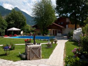 einen Garten mit einem Brunnen und einem Pool in der Unterkunft Gästehaus Gamsei - Bosch Hermann in Grassau