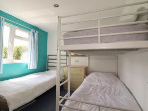 a bedroom with two bunk beds and a window at Trevone - Chalet 130 in Padstow