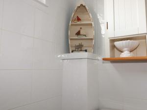 a white bathroom with a shelf and a mirror at Trevone - Chalet 130 in Padstow +11 photos