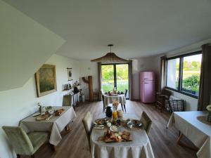 uma sala de estar com duas mesas e um frigorífico rosa em "Au jardin sur l'eau" em Amiens