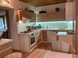 a kitchen with white cabinets and a stove top oven at Chalupa na samote in Pliešovce