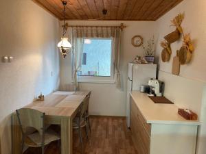 a kitchen with a table and a refrigerator at Chalupa na samote in Pliešovce +14 photos