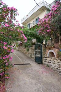 a gate to a house with pink flowers at GuestHouse Panorama Nivice in Sarandë