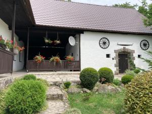 a white house with flowerpots on a fence at Chalupa na samote in Pliešovce