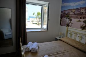 - une chambre avec une fenêtre et des serviettes sur un lit dans l'établissement B&B SAN LORENZO, à Cariati