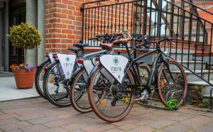 a row of bicycles parked next to a brick building at Hotel St. Bruno in Giżycko