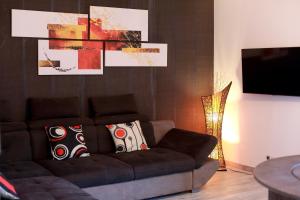 ein Wohnzimmer mit einem Sofa und einem TV in der Unterkunft Appartement T4 centre-ville, plage à 5 min à pied in Sainte-Maxime