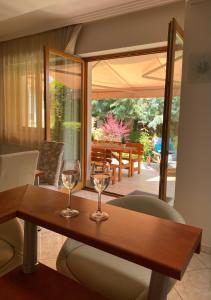 dos copas de vino sentadas en una mesa de madera en Villa Relax Vendégház, en Gárdony