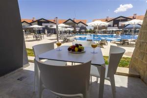 a table with a bowl of fruit and glasses of wine at ZEPHYR Ifrane in Ifrane