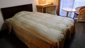 - un lit avec couverture dans une chambre dans l'établissement Sawa Hotel, à Fujikawaguchiko