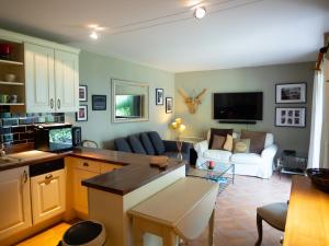 eine Küche und ein Wohnzimmer mit einem Sofa und einem Tisch in der Unterkunft Les Pins, Provence Country Club in Saumane-de-Vaucluse
