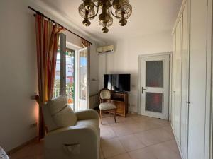 a living room with a couch and a chair and a television at Casa Giusto Ischia in Ischia Town