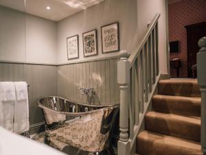 a bathroom with a bath tub next to a staircase at Forss House in Thurso
