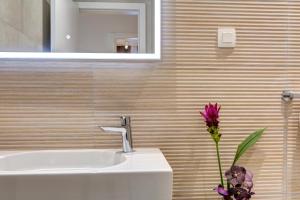 baño con lavabo y jarrón con flor en Four Blue Seasons - Luxury Apartments Dubrovnik en Dubrovnik