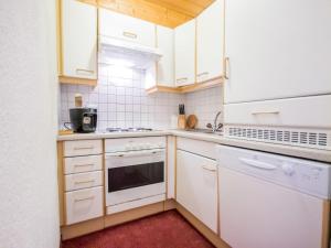 una cucina con armadietti bianchi ed elettrodomestici bianchi di Apartment Conny-1 by Interhome a See