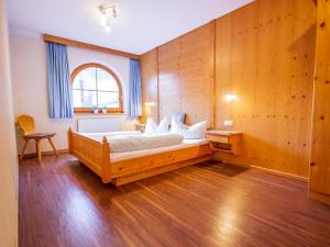 a bedroom with a bed with a wooden wall at Apartment Conny by Interhome in See