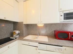 a kitchen with a sink and a red microwave at Apartment Golden Gates by Interhome in Cannes