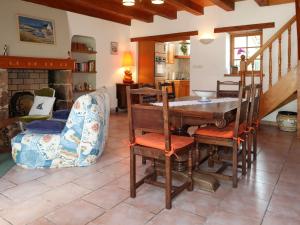 ein Wohnzimmer mit einem Tisch, Stühlen und einem Kamin in der Unterkunft Holiday Home Ty Marieflo by Interhome in Ploemeur