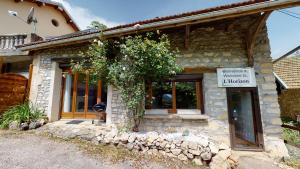 a stone house with a sign in front of it at L'Horizon & SPA in La Burbanche