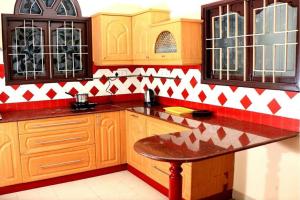 - une cuisine avec des placards en bois et du carrelage rouge et blanc dans l'établissement 4BHK Veda Villa - Near Heritage Town, à Pondichéry