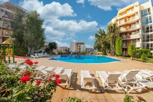 - un groupe de chaises blanches et une piscine dans l'établissement Fort Noks - Menada Apartments, à Sveti Vlas