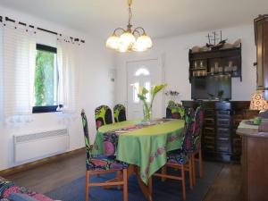 a dining room with a green table and chairs at Apartment Kolic - RAB317 by Interhome in Rab