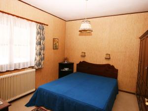 sypialnia z niebieskim łóżkiem i oknem w obiekcie Apartment Eckel-2 by Interhome w mieście Russbach