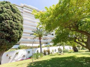 a white building with trees in front of it at Apartment Alexandra Palace-3 by Interhome in Cannes