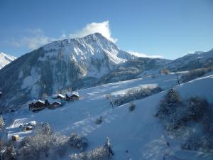 a snow covered mountain with houses in front of it at Studio Soyouz Vanguard-12 by Interhome in Le Corbier