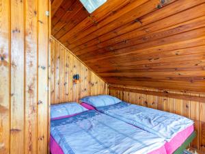 Ce lit se trouve dans une cabane en bois dotée d'un plafond en bois. dans l'établissement Holiday Home Zhorska by Interhome, à Planá nad Lužnicí