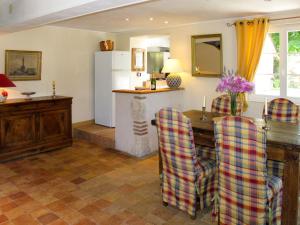 a kitchen with a table and chairs and a refrigerator at Holiday Home La Janverie - MNX200 by Interhome in Monteaux