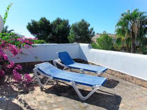 2 chaises bleues assises à côté d'un mur dans l'établissement Holiday Home Dolce Farniente - PCN130 by Interhome, à Cala Mendia