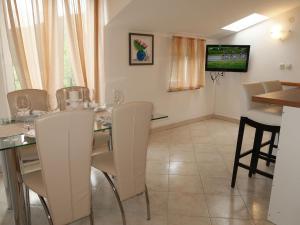 a dining room with a table and chairs and a television at Apartment Marinella - LBN120 by Interhome in Labin