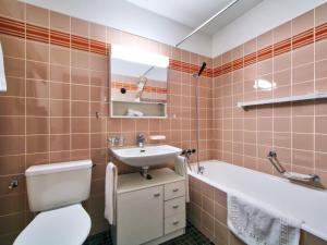 a bathroom with a toilet and a sink and a tub at Apartment Ringstrasse Apt 212 by Interhome in Leukerbad +14 photos