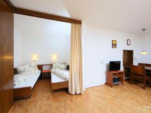 a room with a bed and a desk and a television at Apartment Ringstrasse Apt 212 by Interhome in Leukerbad