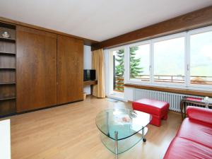a living room with a red couch and a glass table at Apartment Ringstrasse - Utoring-7 by Interhome in Leukerbad