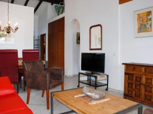 ein Wohnzimmer mit einem TV und einem Tisch in der Unterkunft Apartment Miralago - Utoring-17 by Interhome in Piazzogna