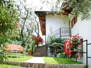 a house with a staircase and red flowers at Apartment Delvai-1 by Interhome in Brenzone sul Garda