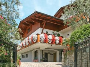 a house with red and white flowers on the balcony at Apartment Delvai-1 by Interhome in Brenzone sul Garda