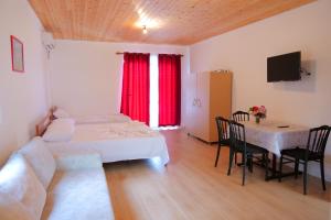a living room with a bed and a table with chairs at GuestHouse Panorama Nivice in Sarandë