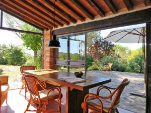 un patio con mesa, sillas y sombrilla en Holiday Home Lara by Interhome, en Boccheggiano